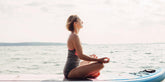 Lady practicing yoga on a Newell paddleboard.